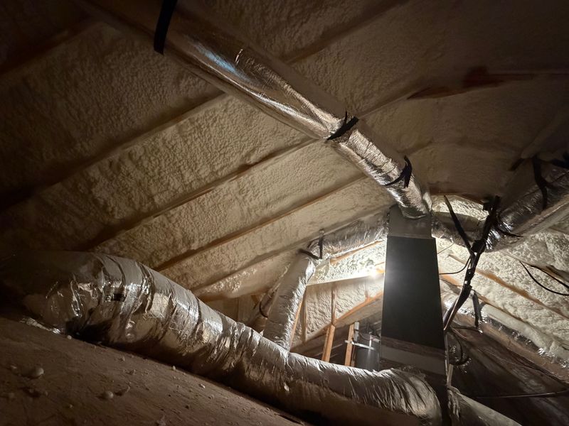 Spray foam insulation around attic ducts